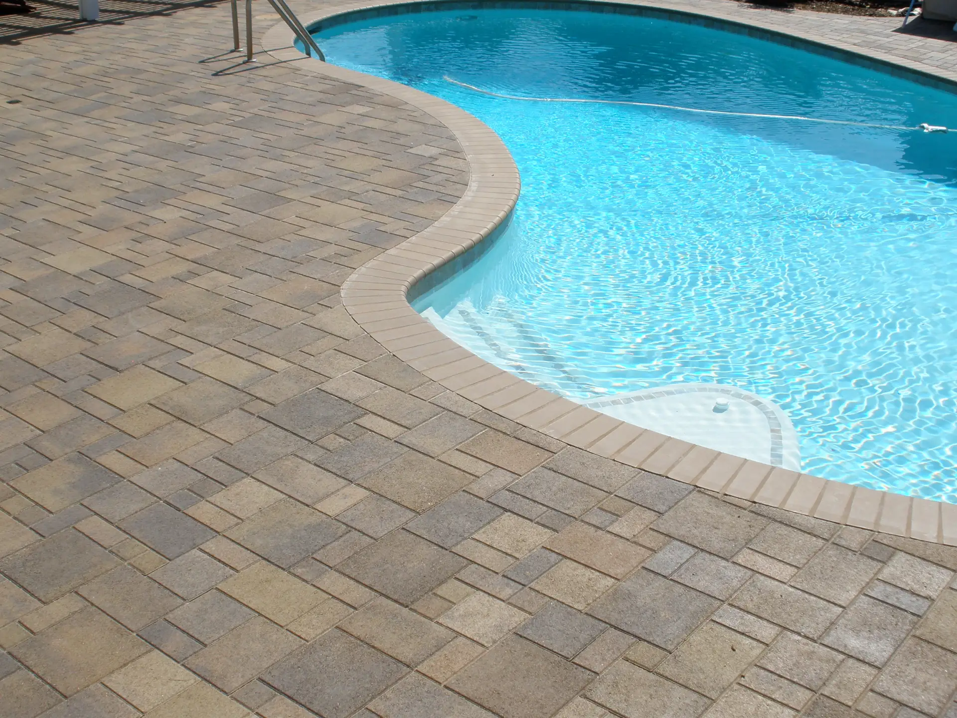 Swimming pool surrounded by new stone pavers.