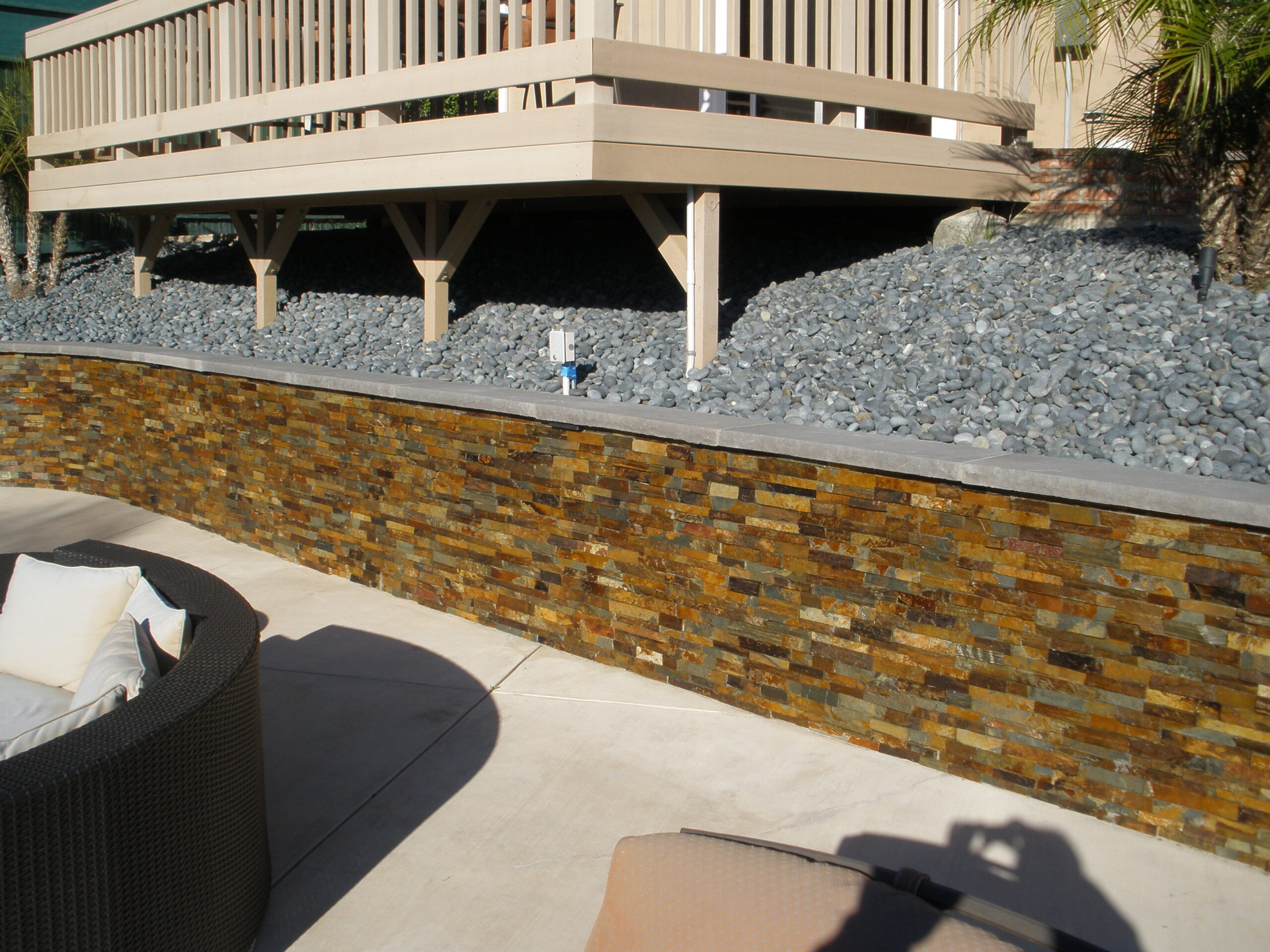 Gorgeous new stone wall next to outdoor patio with amazing color and finish.