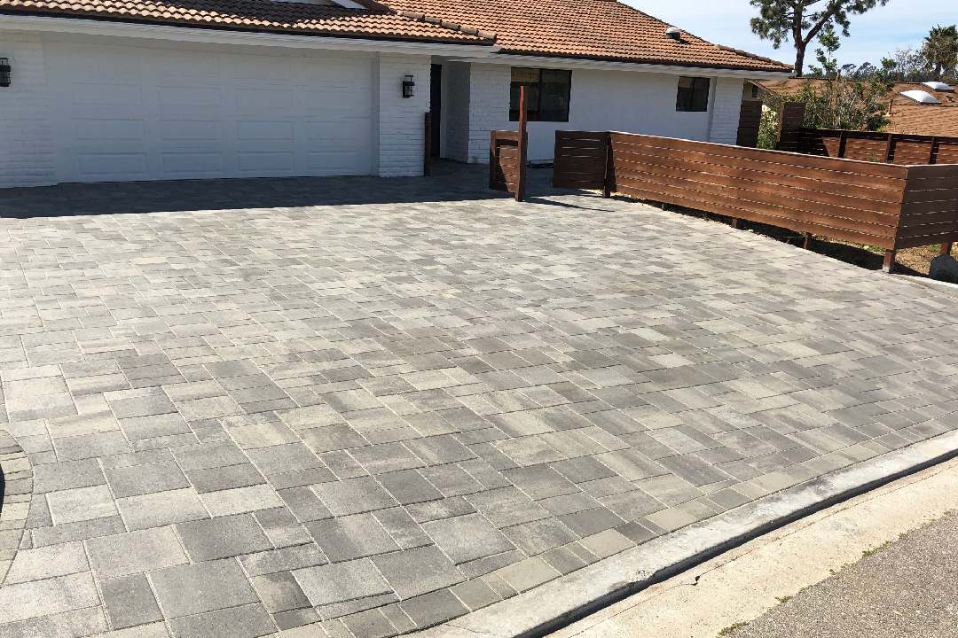 New concrete stone paved driveway in front yard of house.