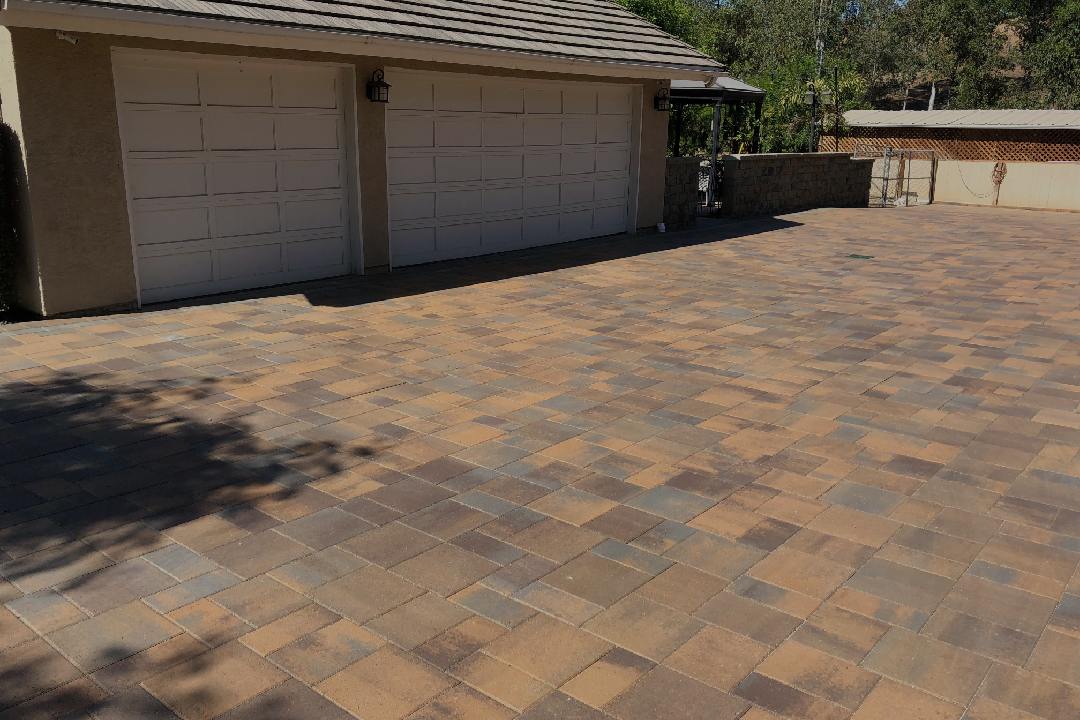 Newly finished driveway pavers next to garage.